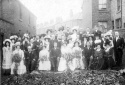The wedding of James Edwardson and Elizabeth Pile took place at St Ambrose
Church, Widnes on 28 June 1909.  The photograph was taken in the garden at the
side of Bradley Cottage (left) in Albert Road.  Elizabeth Pile was married from
113 Albert Road (just off the picture).  In the background is Cooper Street.  A
petrol filling station now occupies the site.  [Bradley Cottage had previously
belonged to John Edwardson (b.1802), uncle of James Edwardson.]